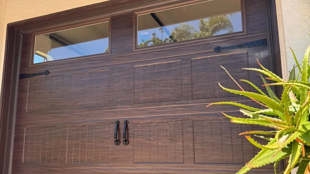 Wood-grain carriage garage door with black hardware in Ontario, CA